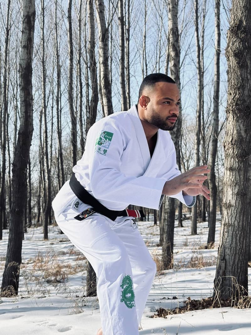 Person practicing in the ZHAN Year of the Dragon Limited Edition BJJ Gi in a snowy forest.