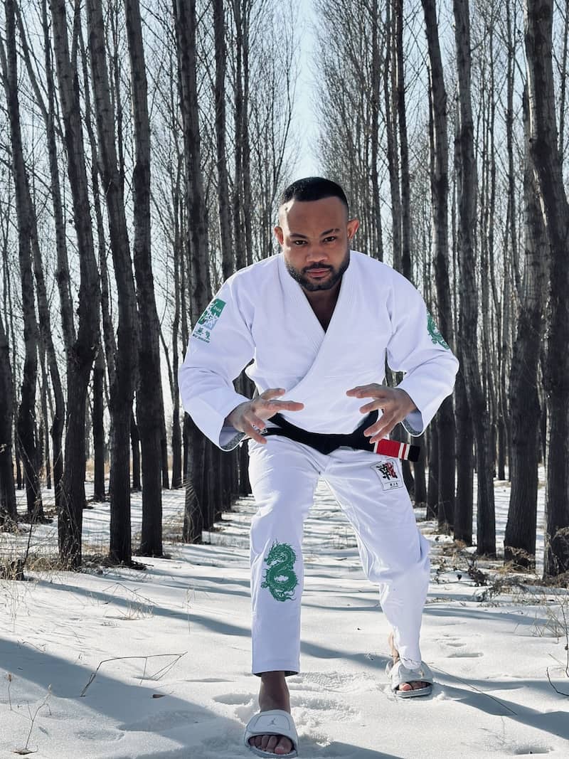 Man demonstrating the ZHAN Year of the Dragon Limited Edition BJJ Gi in a snowy landscape.