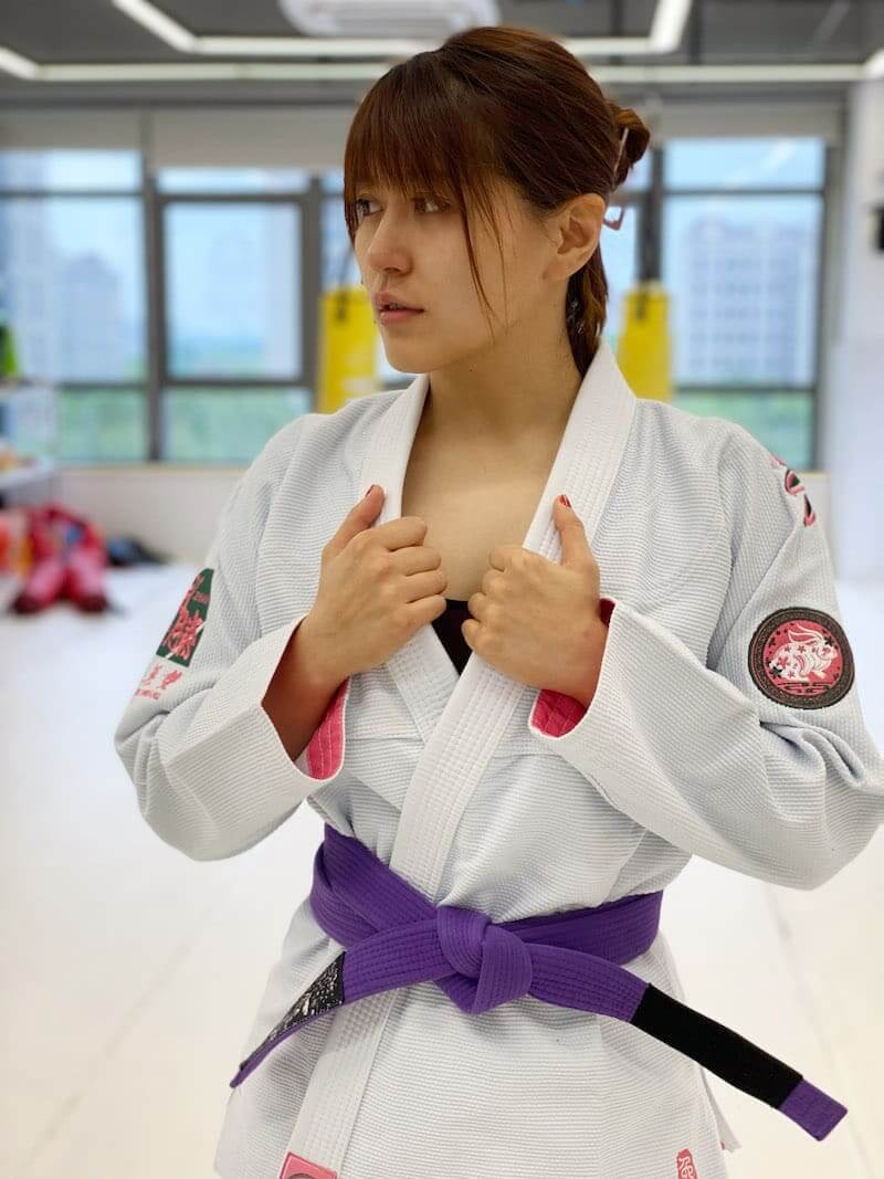 ZHAN Women's Year of the Rabbit BJJ Gi: Embrace Tradition & Elegance worn by a female martial artist in a training studio.