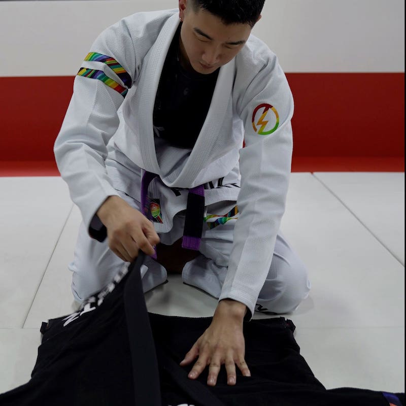 BLITZ DEFENSE Series Rainbow BJJ Set: Durable & Stylish Gi being prepared by a practitioner on the mat.
