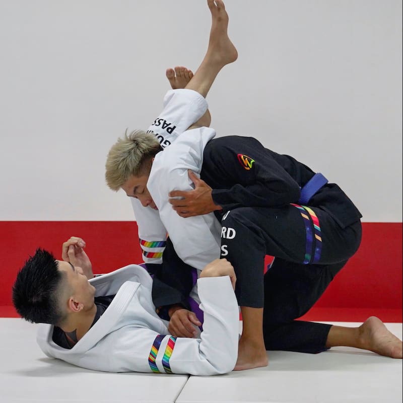 BLITZ DEFENSE Series Rainbow BJJ Set: Durable & Stylish Gi demonstrated in dynamic Brazilian Jiu-Jitsu practice.
