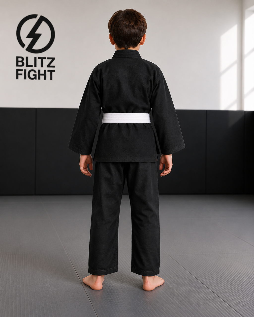 Boy in BLITZ Kids Basic BJJ Gi, training in a martial arts dojo, showcasing a practical and durable design.