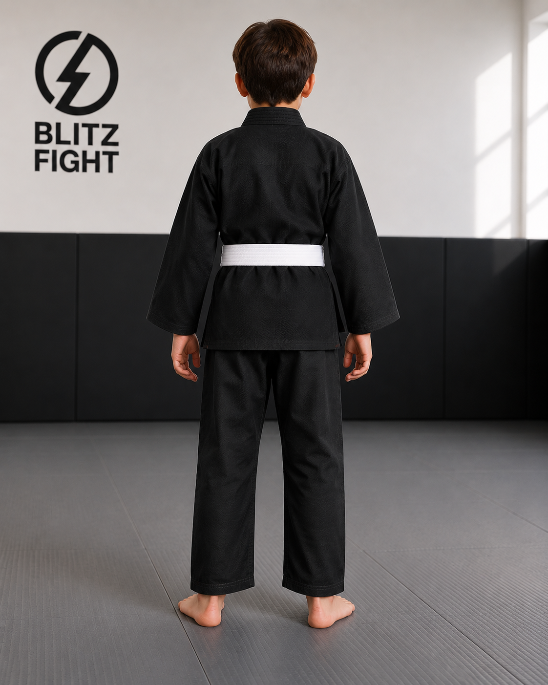 Boy in BLITZ Kids Basic BJJ Gi, training in a martial arts dojo, showcasing a practical and durable design.