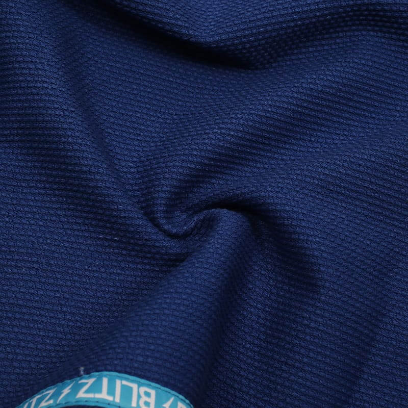 BLITZ Kids Classic BJJ Gi: Tradition & Excellence fabric texture close-up in blue color.