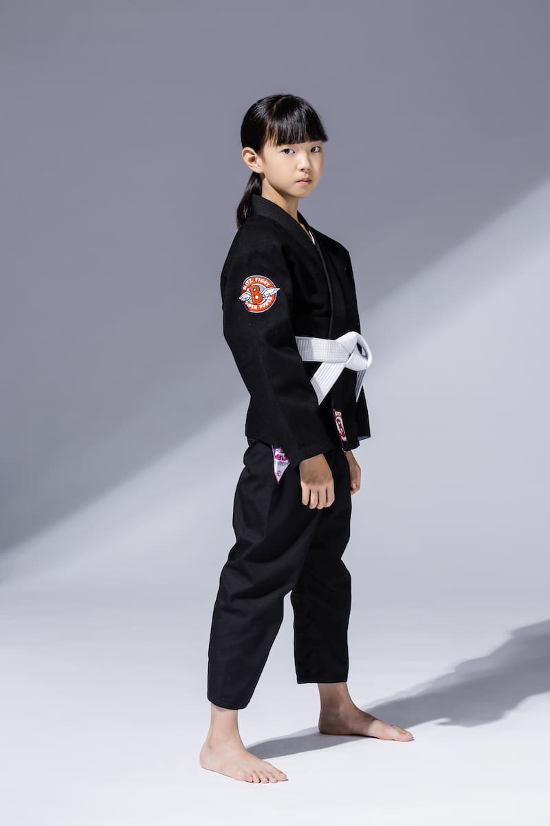 BLITZ Kids Super Power BJJ Gi worn by a young martial artist in a dynamic pose, showcasing comfort and style.
