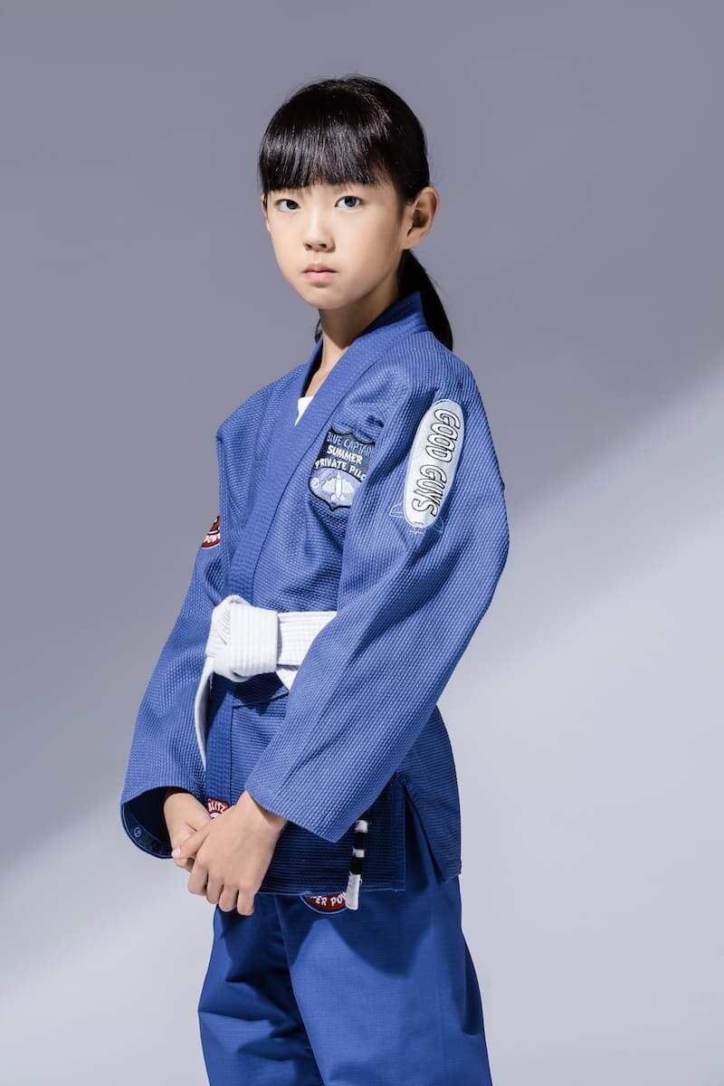 Child wearing BLITZ Kids Super Power BJJ Gi, showcasing a comfortable fit and fun design for young martial artists.