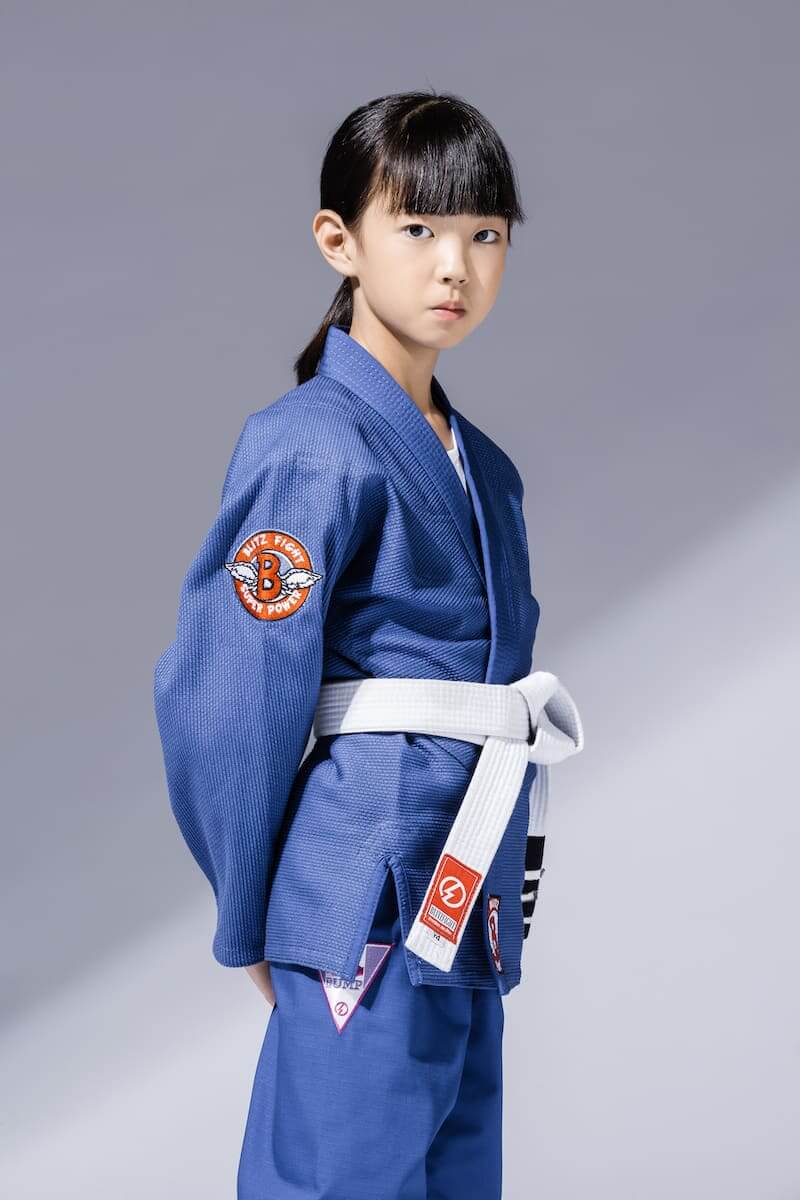 BLITZ Kids Super Power BJJ Gi worn by a young girl, showcasing a durable and comfortable design for Brazilian Jiu-Jitsu.