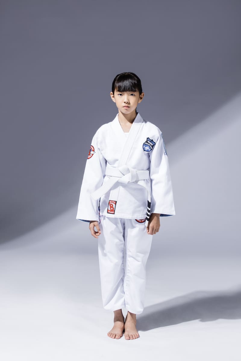 A child wearing a BLITZ Kids Super Power BJJ Gi, showcasing its comfortable and durable design for young athletes.