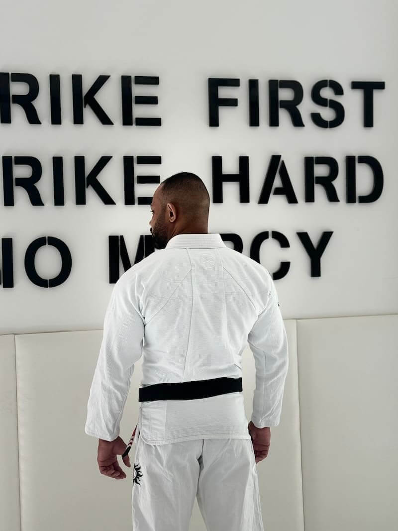 BLITZ Sun & Moon Brazilian Jiu-Jitsu Gi worn by man facing wall with motivational quotes.