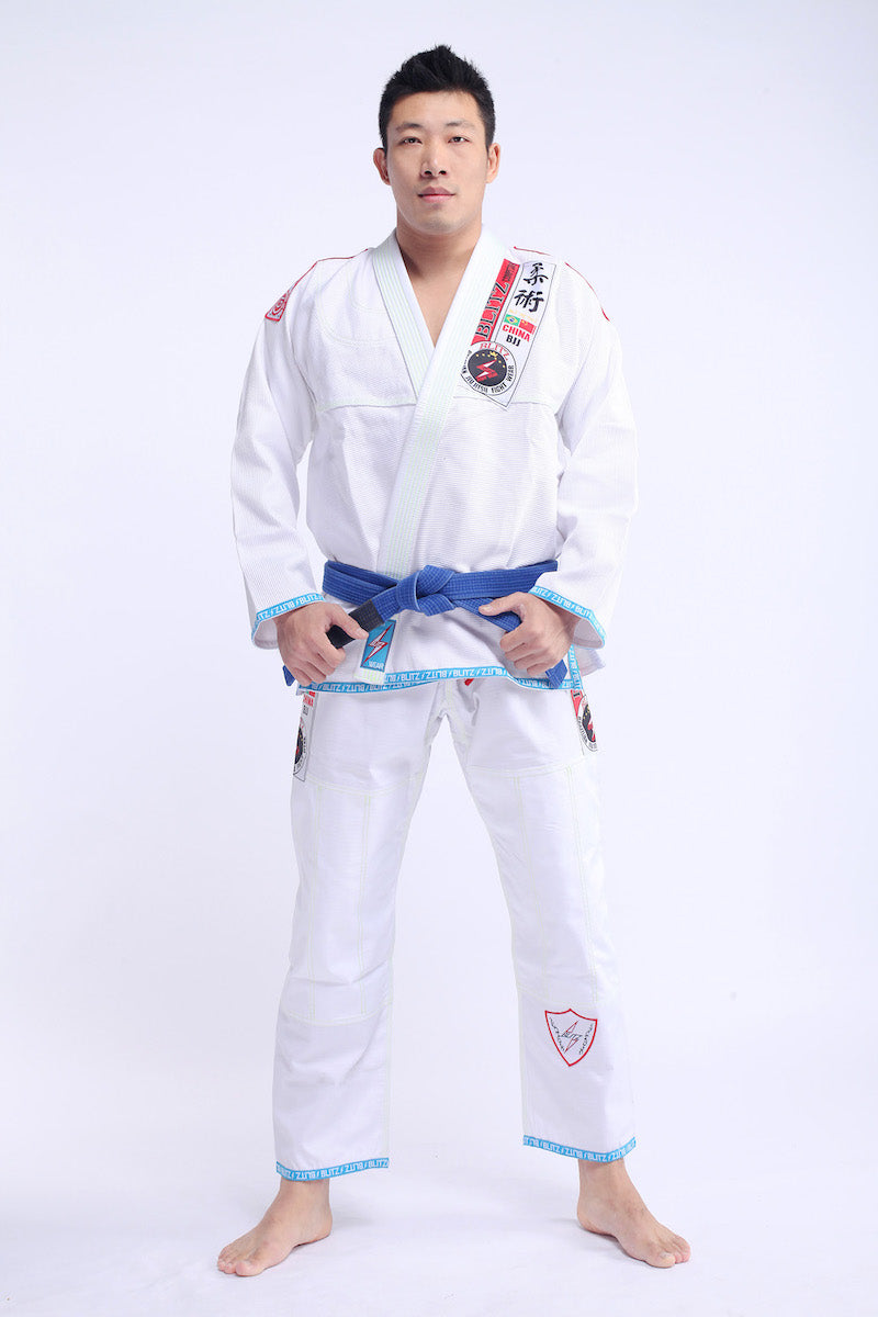 Classic BLITZ BJJ Gi: Embrace Excellence & Tradition worn by practitioner in white and blue.