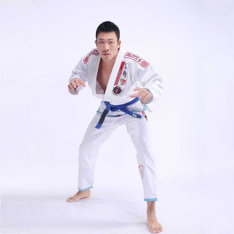 Classic BLITZ BJJ Gi: Embrace Excellence & Tradition worn by a practitioner in a combat stance.