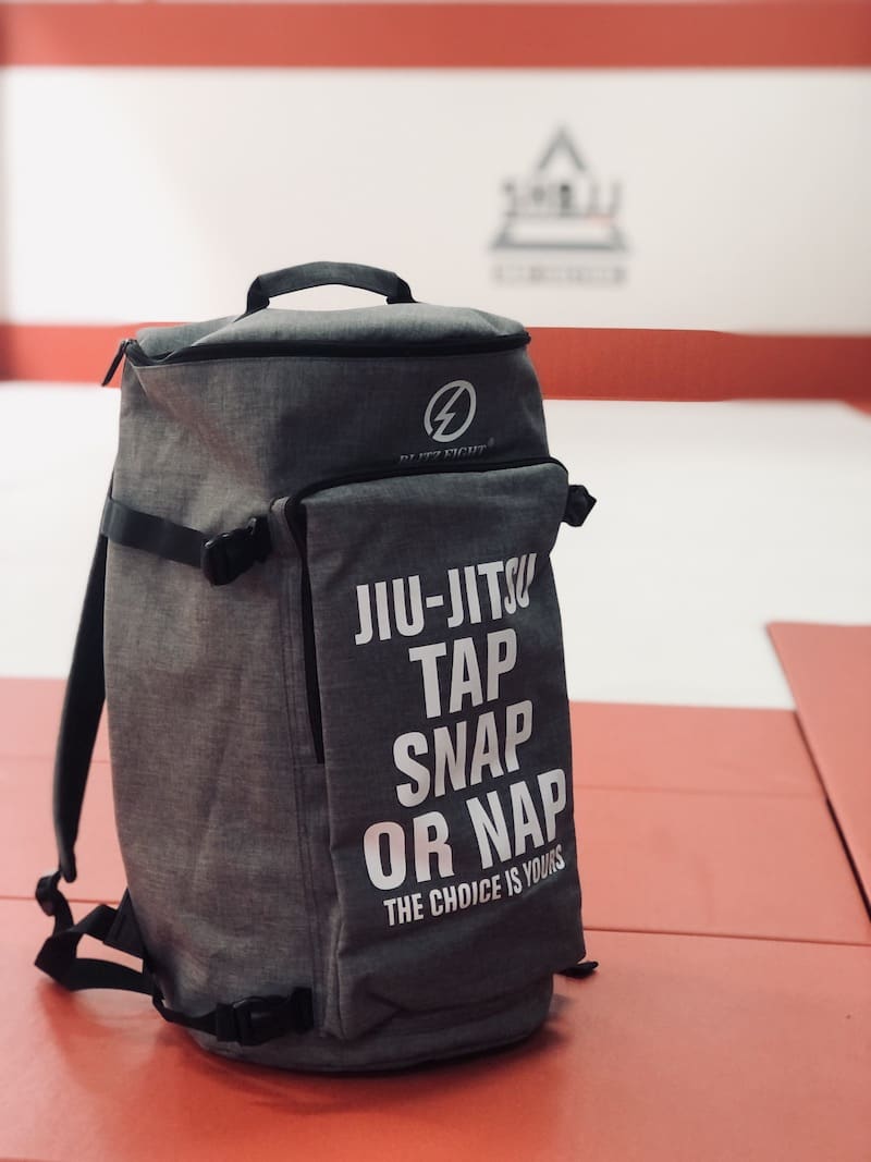 Ultimate BJJ Backpack: Spacious & Durable Gear Bag for Martial Artists on a training mat.
