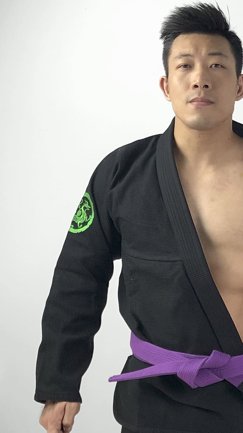 ZHAN Azure Dragon BJJ Gi worn by a martial artist, showcasing dragon-themed embroidery and a purple belt.