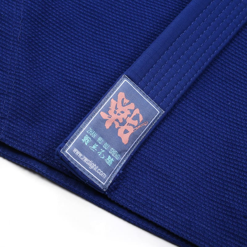 ZHAN Basic Women's BJJ Gi: Embrace Elegance & Performance label on blue Gi fabric.