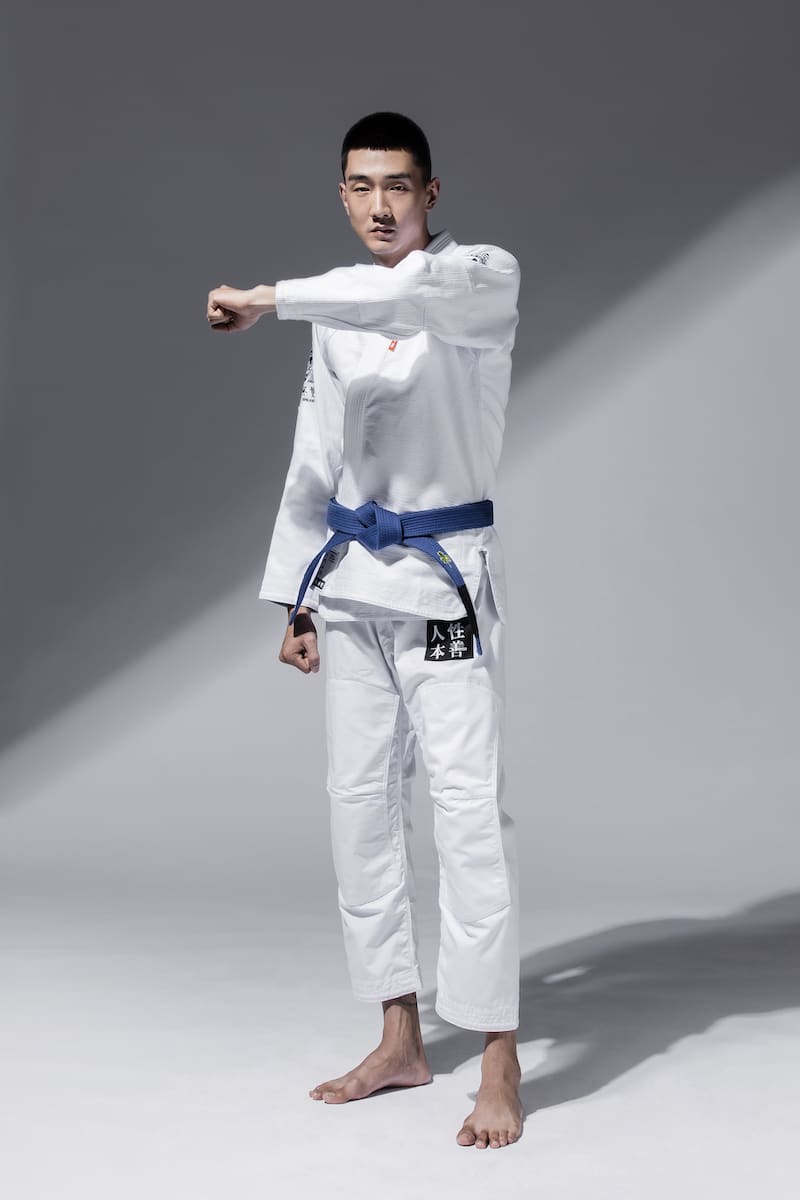 ZHAN Good vs Evil BJJ Gi worn by a practitioner demonstrating a pose in a studio setting.