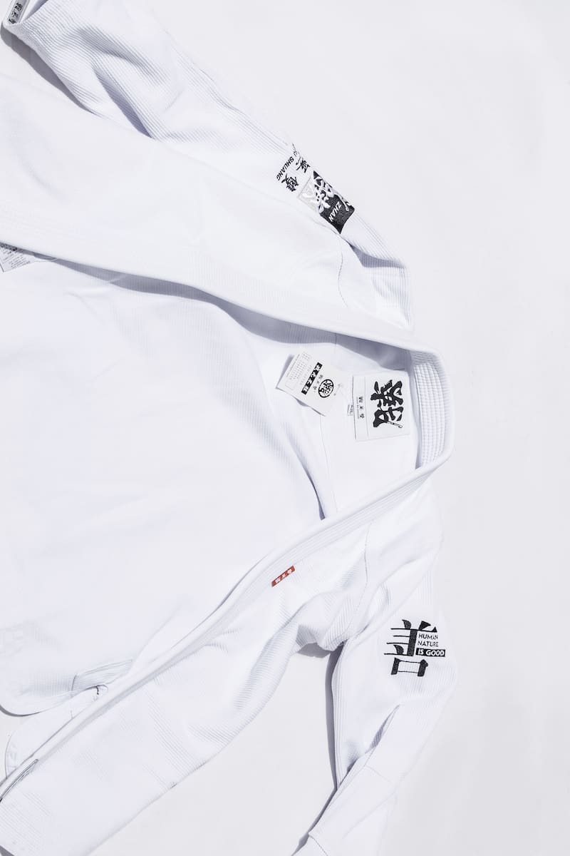ZHAN Good vs Evil BJJ Gi featuring a white kimono with unique designs and labels.