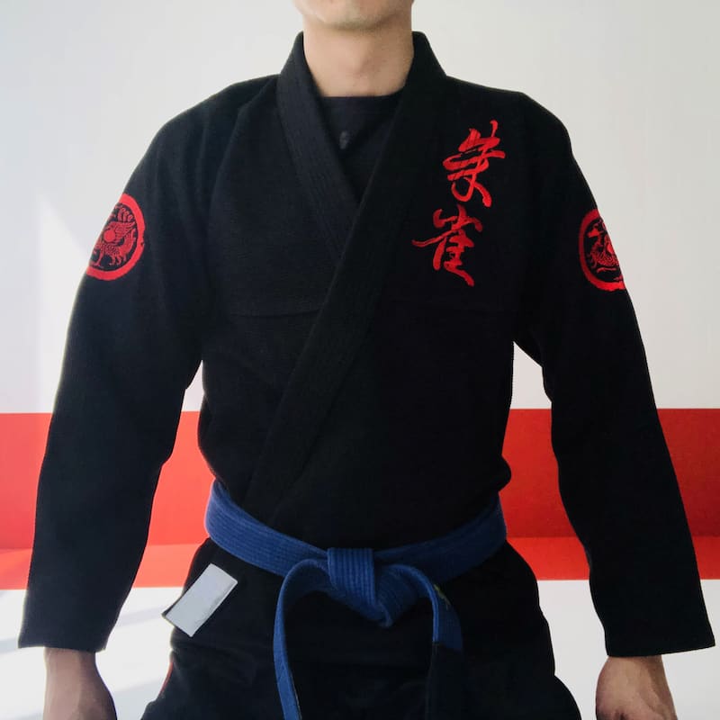 ZHAN Vermilion Phoenix BJJ Gi worn by a martial artist showcasing detailed embroidery and a blue belt.