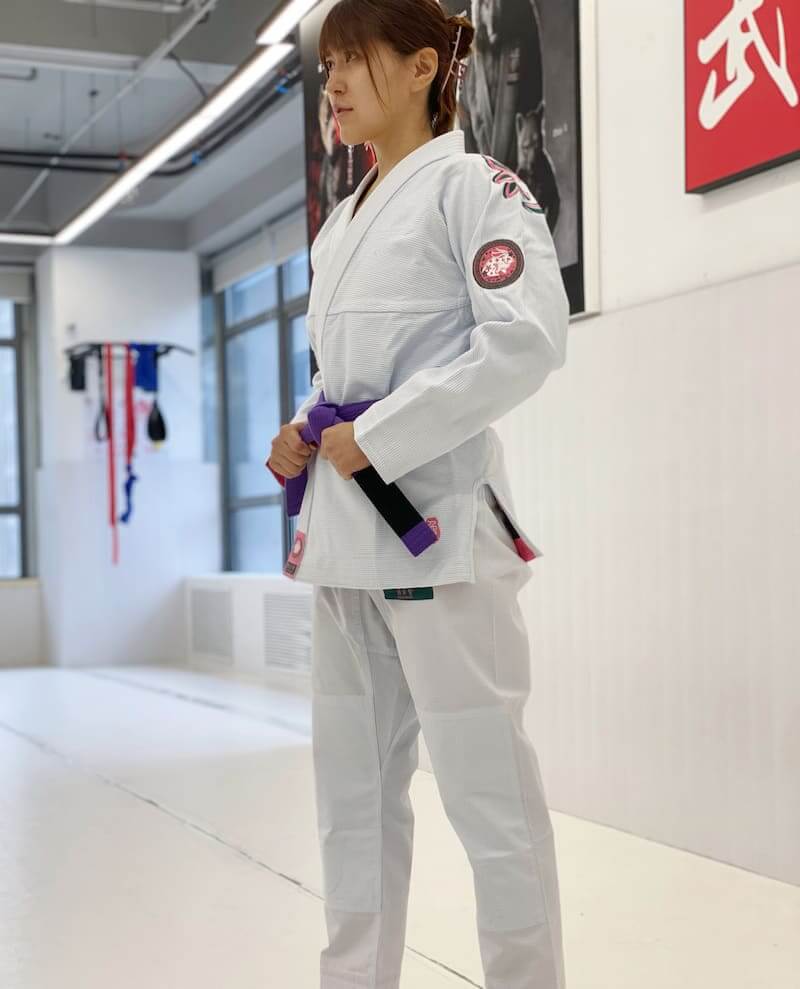 ZHAN Women's Year of the Rabbit BJJ Gi: Embrace Tradition & Elegance worn by a woman in a dojo setting.