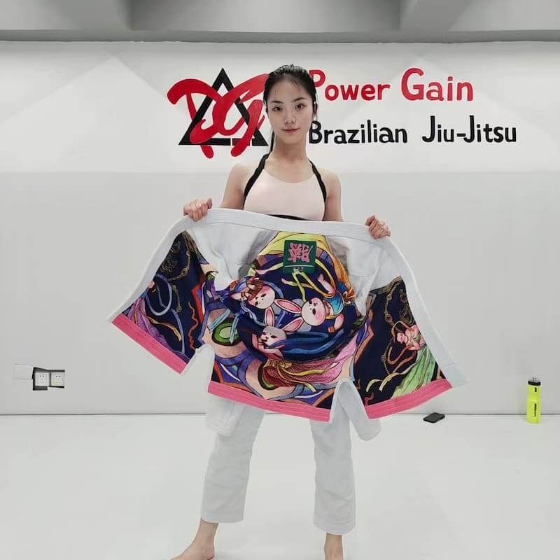 ZHAN Women's Year of the Rabbit BJJ Gi: Embrace Tradition & Elegance displayed on model showcasing intricate designs.